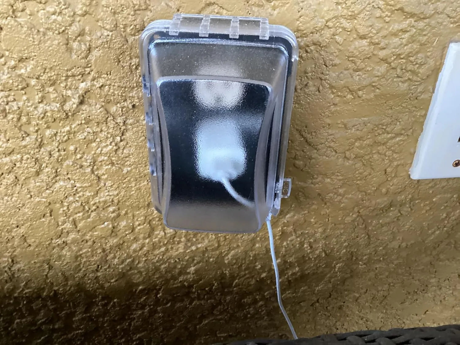 Customer photo of in-use outlet cover protecting outdoor electrical outlet from weather