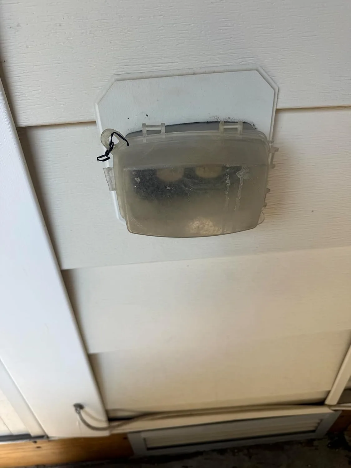 Customer photo showing in-use outlet cover protecting outdoor electrical outlet from weather