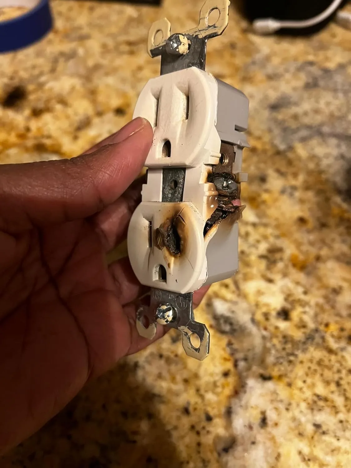 Customer photo of backstab outlet terminals showing failed wire connection