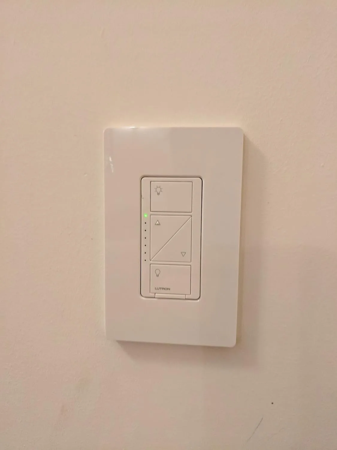 Customer photo of smart dimmer switch installed in wall with LED bulbs dimmed to different brightness levels