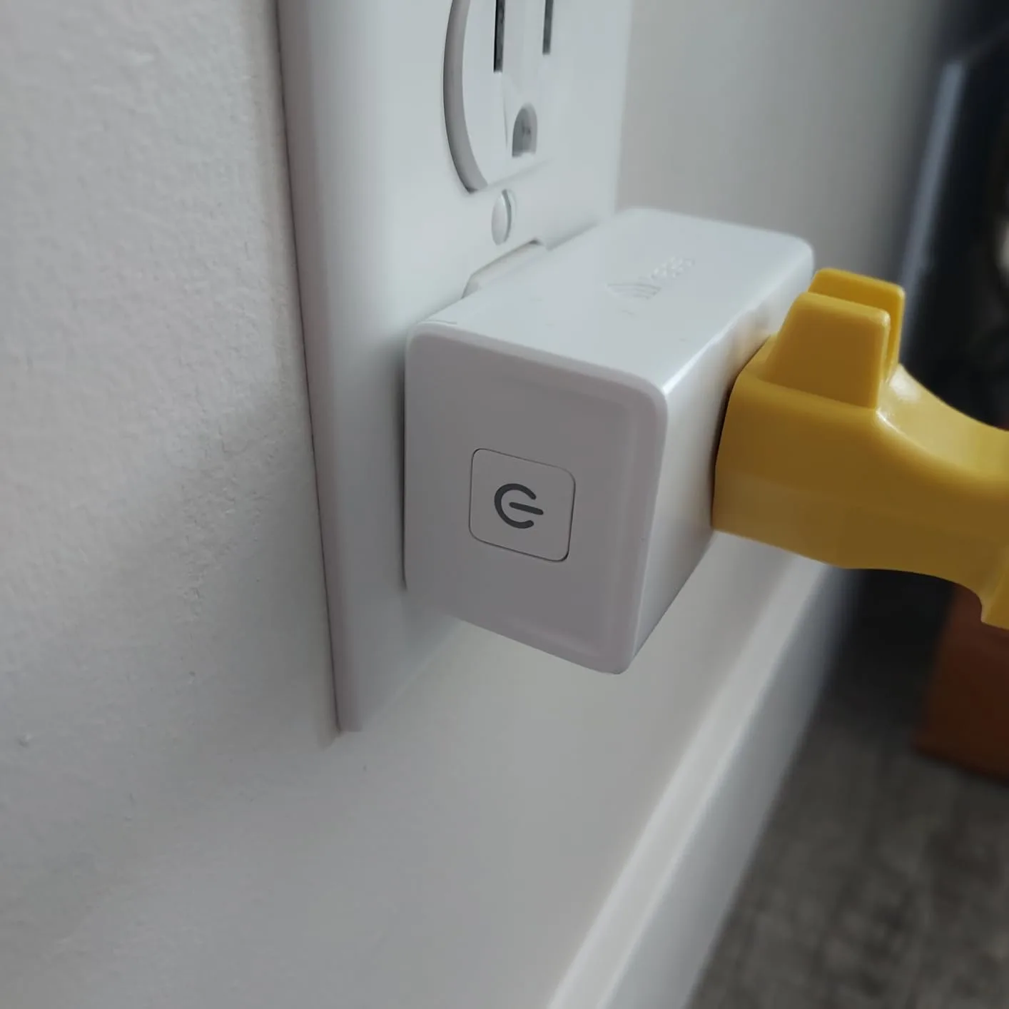 Customer photo of smart plug installed in wall outlet next to traditional switch