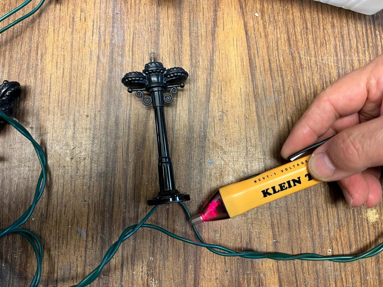 Customer photo of non-contact voltage tester being used to test electrical outlet safety