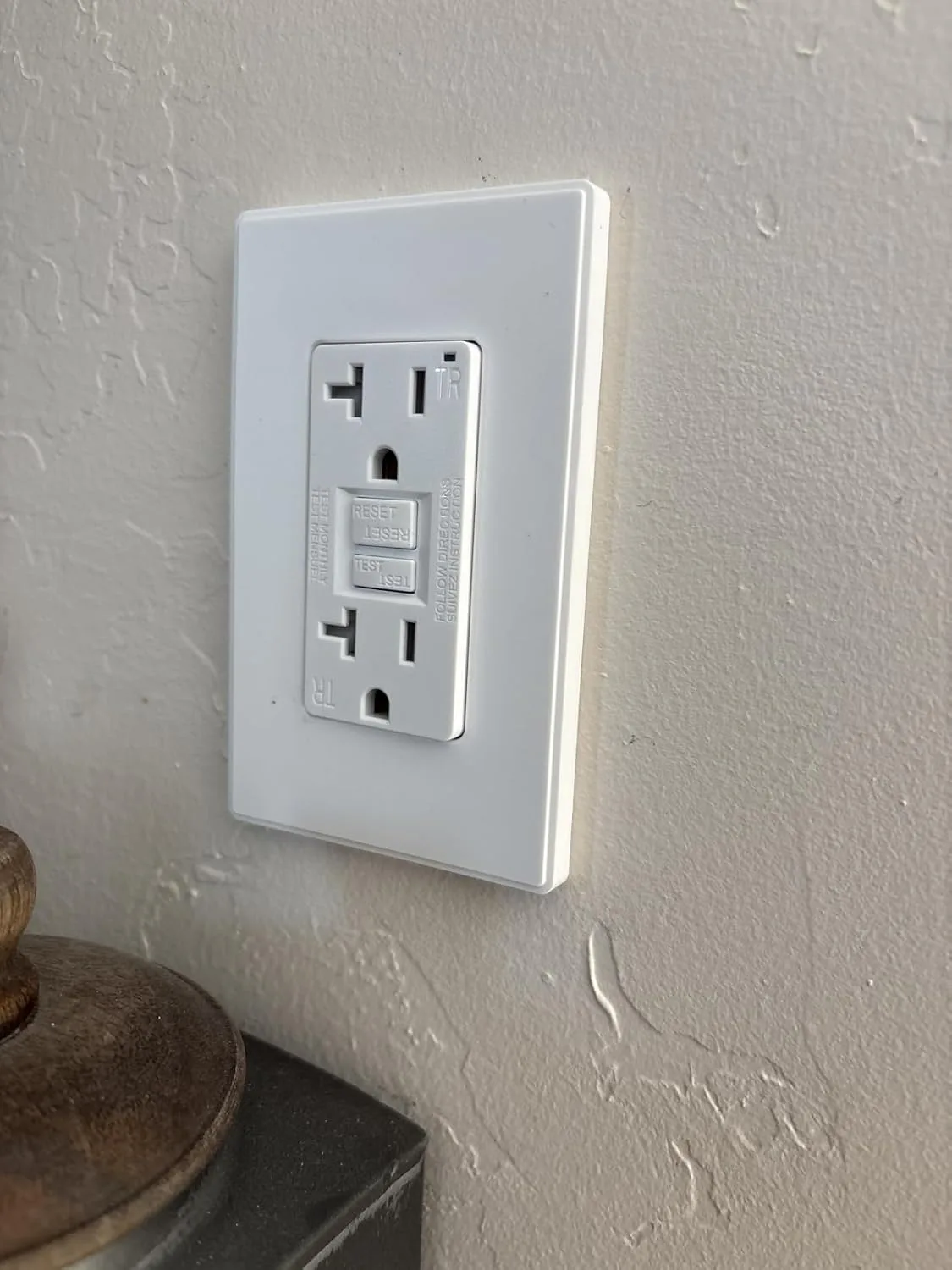 Customer photo of dual function GFCI/AFCI outlet installed in kitchen wall outlet